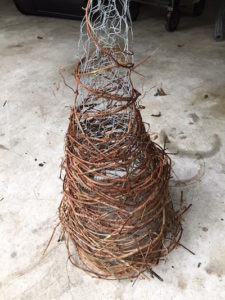 Adding vines to chicken wire cone for DIY grapevine Christmas Trees