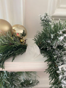 Using Gaffers tape to hold up inexpensive Walmart garland on fireplace mantel
