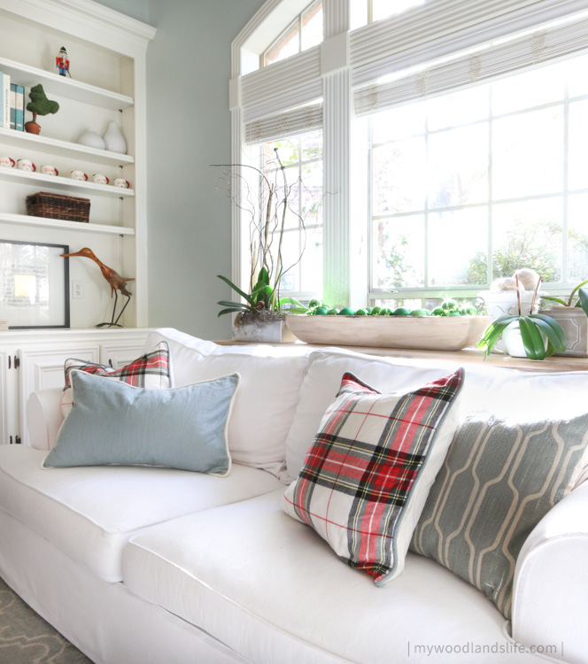 White couch with plaid holiday pillows and neutral coastal decor