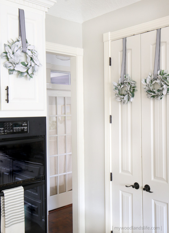 Lambs ear wreaths hang from kitchen cabinets for neutral Christmas decor