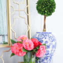 Blue and white vase with topiary and camelia flowers and peel and stick wallpaper in green chevron pattern
