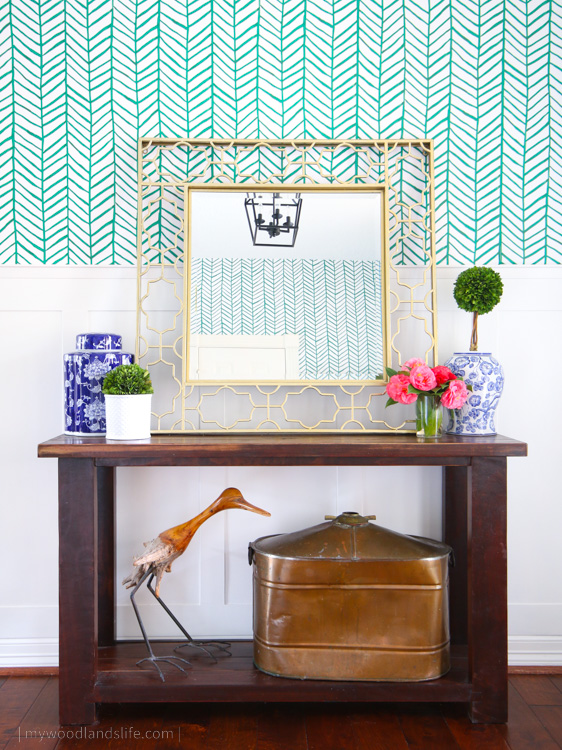Entryway table with blue and white vase decor and chevron green peel and stick wallpaper