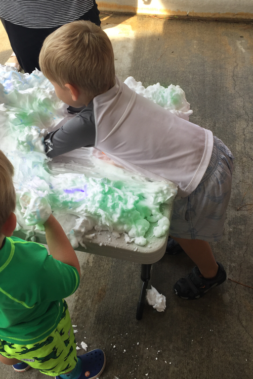 Toddler playing with shaving cream on table