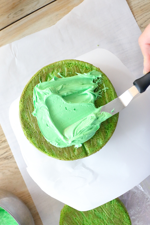 Spreading green icing on base of Om Nom cake