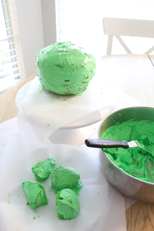 Crumb coat of green icing on Om Nom birthday cake