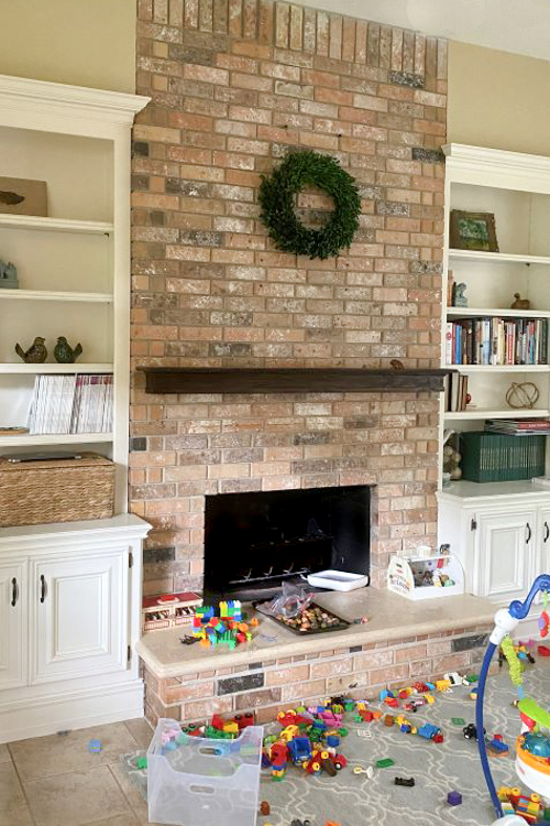 Brick fireplace with built-in shelves on either side