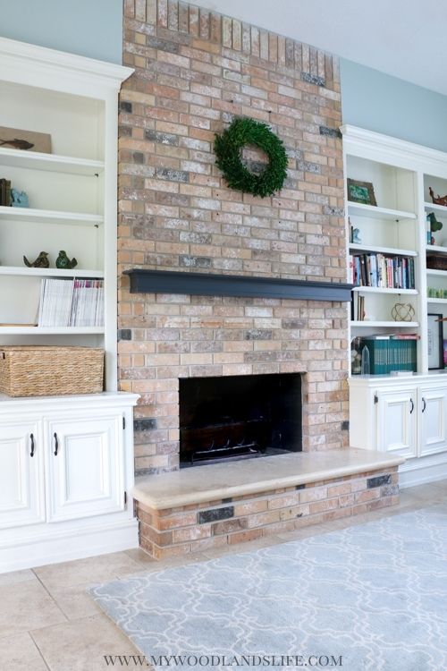Family room fireplace with built in white shelves and coastal gray blue walls